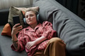 Young Caucasian Woman with Prosthetic Arm Using Smartphone and Wearing Headphones - PhotoDune Item for Sale