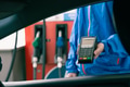 Closeup gas station staff worker with credit card swiping machine for payment, Petroleum business - PhotoDune Item for Sale