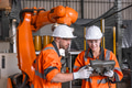 Robotic technician engineer male training helping young women team control operate robot welding arm - PhotoDune Item for Sale
