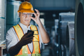Professional engineer man working in heavy metal industry looking at handheld smart device at night - PhotoDune Item for Sale