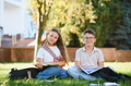 School children studying outdoors on grass in park - PhotoDune Item for Sale