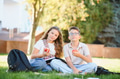 Schoolchildren friends eating apples during break on grass - PhotoDune Item for Sale