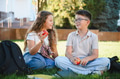 Students enjoying break time eating apples outdoors - PhotoDune Item for Sale