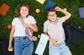Schoolchildren relaxing on grass with books and apples - PhotoDune Item for Sale