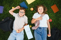 School children relaxing on grass with apples and books - PhotoDune Item for Sale
