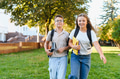 Schoolchildren walking on campus carrying books outdoors - PhotoDune Item for Sale