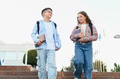 Schoolchildren walking on campus carrying books and backpacks - PhotoDune Item for Sale