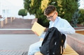 Young boy student putting book in backpack on campus - PhotoDune Item for Sale