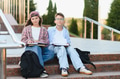 Schoolchildren sitting on stairs studying outside campus - PhotoDune Item for Sale