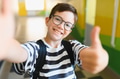 Smiling student taking selfie and giving thumbs up at school - PhotoDune Item for Sale