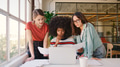 Three Young Businesswomen Working On Laptop At Desk In Modern Office - PhotoDune Item for Sale