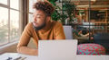 Young Businessman With Piercing At Desk Working On Laptop In Modern Office Looking Out Of Window - PhotoDune Item for Sale