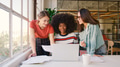 Three Young Businesswomen Working On Laptop At Desk In Modern Office - PhotoDune Item for Sale
