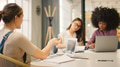 Young Multi Cultural Female Business Team Meeting Around Table In Modern Office - PhotoDune Item for Sale