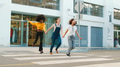 Three Young Smiling Female Friends Outdoors Holding Hands On Crosswalk In City - PhotoDune Item for Sale