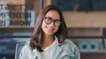 Portrait Of Young Smiling Businesswoman Wearing Glasses Sitting At Desk In Modern Office - PhotoDune Item for Sale