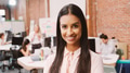 Portrait Of Smiling Young Businesswoman Standing Against Brick Wall In Modern Office - PhotoDune Item for Sale
