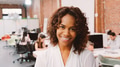 Portrait Of Smiling Businesswoman Standing Against Brick Wall In Modern Office - PhotoDune Item for Sale