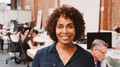Smiling Mature Businesswoman Standing Against Brick Wall In Modern Office - PhotoDune Item for Sale