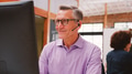 Mature Male Customer Services Agent Working At Desk In Call Center - PhotoDune Item for Sale