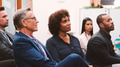 Group Of Businessmen And Businesswomen Listening To Presentation At Conference - PhotoDune Item for Sale
