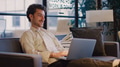 Young Smiling Businessman Working On Laptop In Informal Seating Area Of Modern Office - PhotoDune Item for Sale
