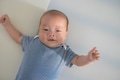 Newborn baby with blue outfit lying on bed - PhotoDune Item for Sale