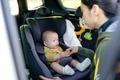 Mother placing baby safely into car seat - PhotoDune Item for Sale