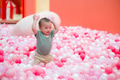 Cute baby sitting and playing in ball pool - PhotoDune Item for Sale
