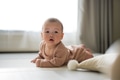 Adorable baby looking up while lying indoor - PhotoDune Item for Sale