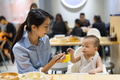 Mother feeding baby boy at restaurant table - PhotoDune Item for Sale