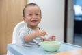 Happy baby eating food at home table - PhotoDune Item for Sale