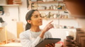 Female Potter In Ceramics Studio Checking Orders Using Digital Tablet - PhotoDune Item for Sale