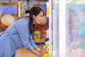 Woman playing claw machine at arcade indoors - PhotoDune Item for Sale