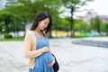 Pregnant woman look at the tummy in the park - PhotoDune Item for Sale