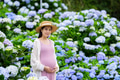 Beautiful Pregnant woman in the hydrangea flower garden - PhotoDune Item for Sale