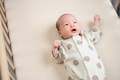 Newborn baby son lying quietly in wooden crib - PhotoDune Item for Sale