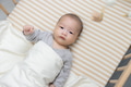 Baby lying in crib entertained by hanging toy - PhotoDune Item for Sale