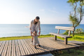 Parent helping baby take first steps near water - PhotoDune Item for Sale