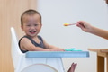 Happy baby eating food at home table - PhotoDune Item for Sale