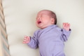 Crying newborn baby lying on cozy bed - PhotoDune Item for Sale