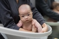 Mother bathing newborn baby in warm water - PhotoDune Item for Sale