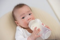 Adorable baby enjoying fresh milk bottle indoors - PhotoDune Item for Sale