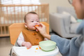 Baby making funny face after carrot taste by his mum - PhotoDune Item for Sale