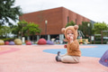Infant wearing bear hat sitting alone in park - PhotoDune Item for Sale