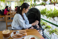 Young mother at restaurant with newborn baby in stroller - PhotoDune Item for Sale