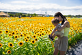 Loving mother spending day with baby in sunflower field - PhotoDune Item for Sale