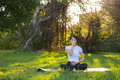 Woman practicing pranayama sitting on grass outdoors - PhotoDune Item for Sale