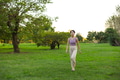 Woman walking on grass wearing casual yoga wear - PhotoDune Item for Sale