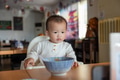 Baby eating food while watching phone at restaurant - PhotoDune Item for Sale